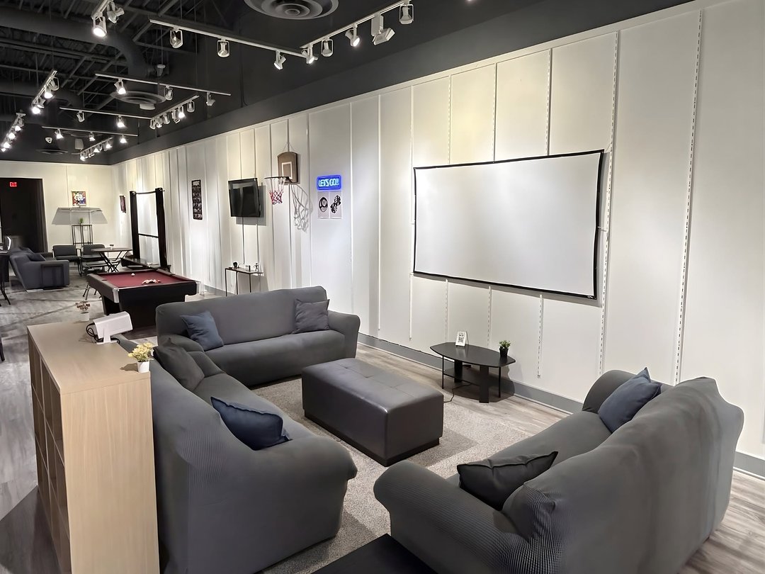 The lounge at Chil_Space with sectional sofas and the projector wall